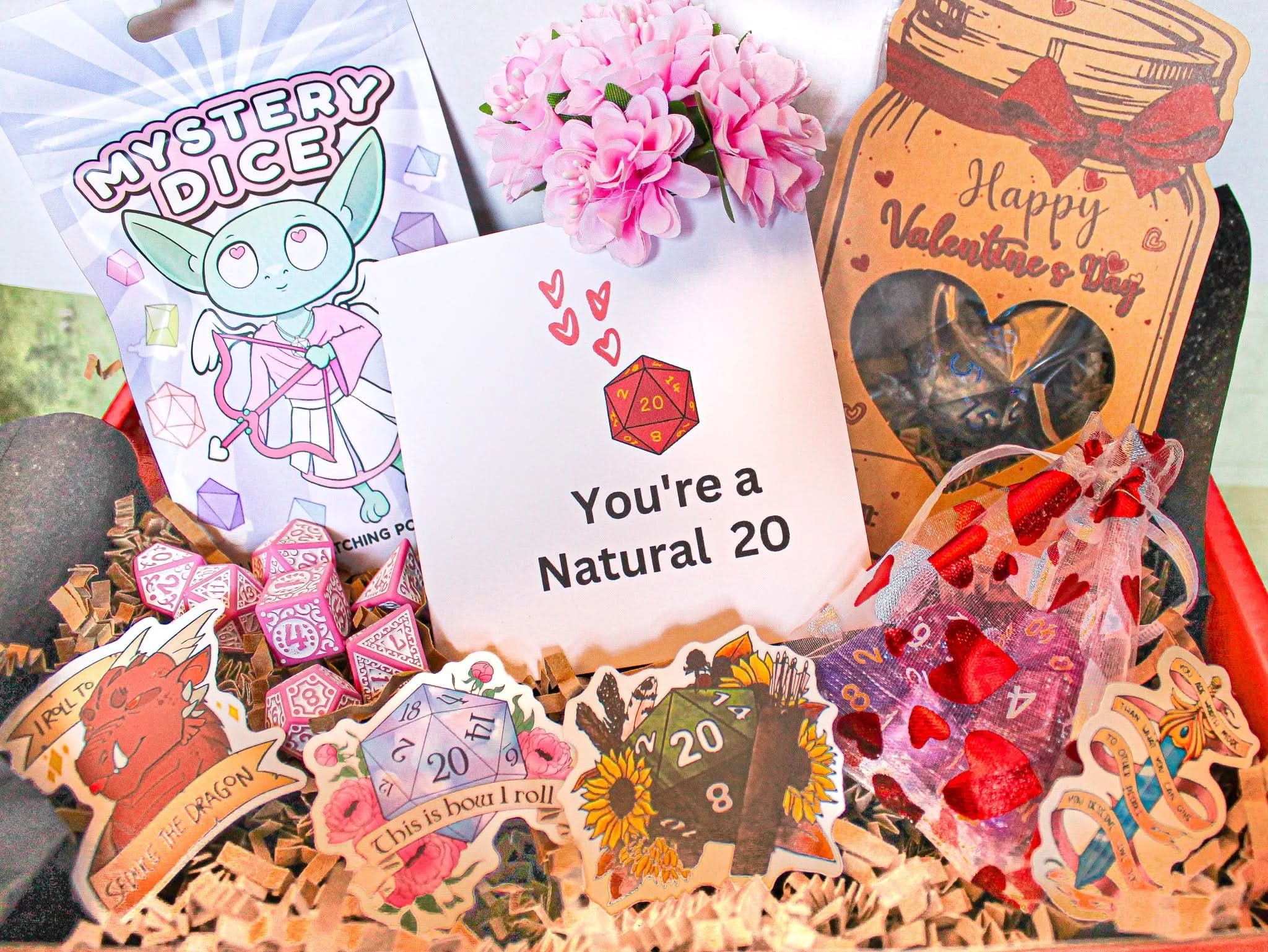 A gift box containing various items related to role-playing games, including dice bags, a Valentine's card, and decorative flowers, all arranged to represent a gift for Valentine's Day.