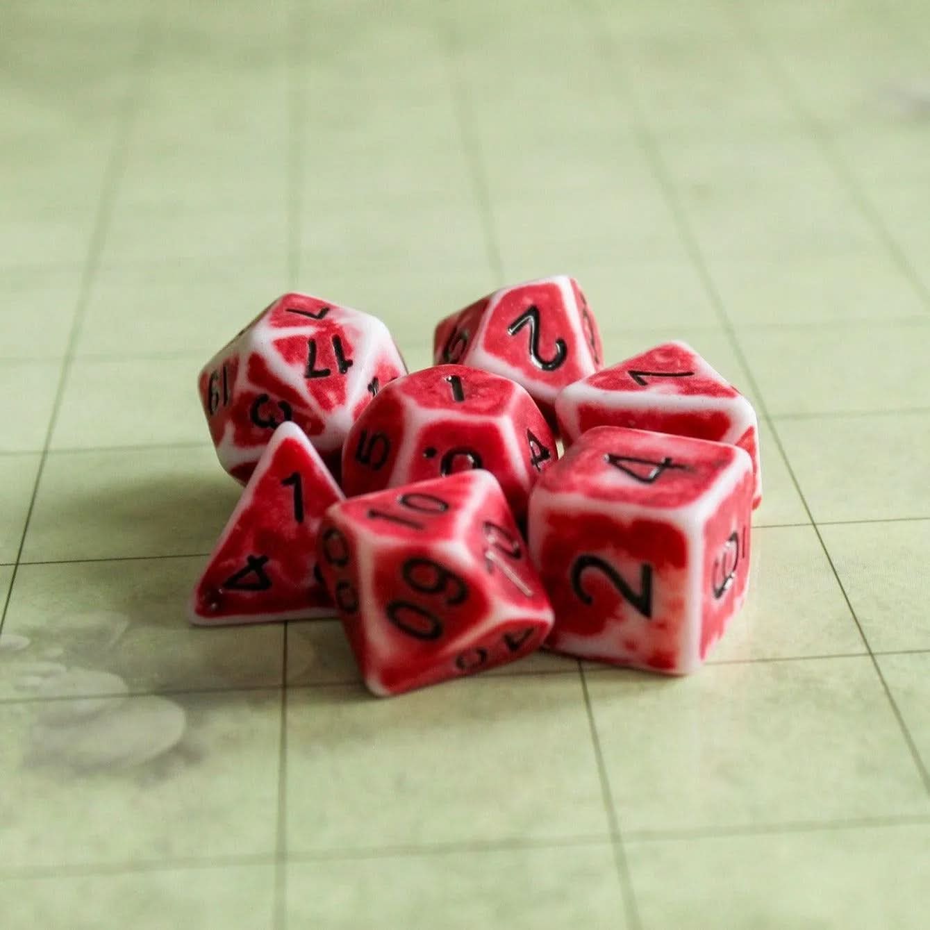 a side view of red dice laying down on a TTRPG table- MysteryDiceGoblins