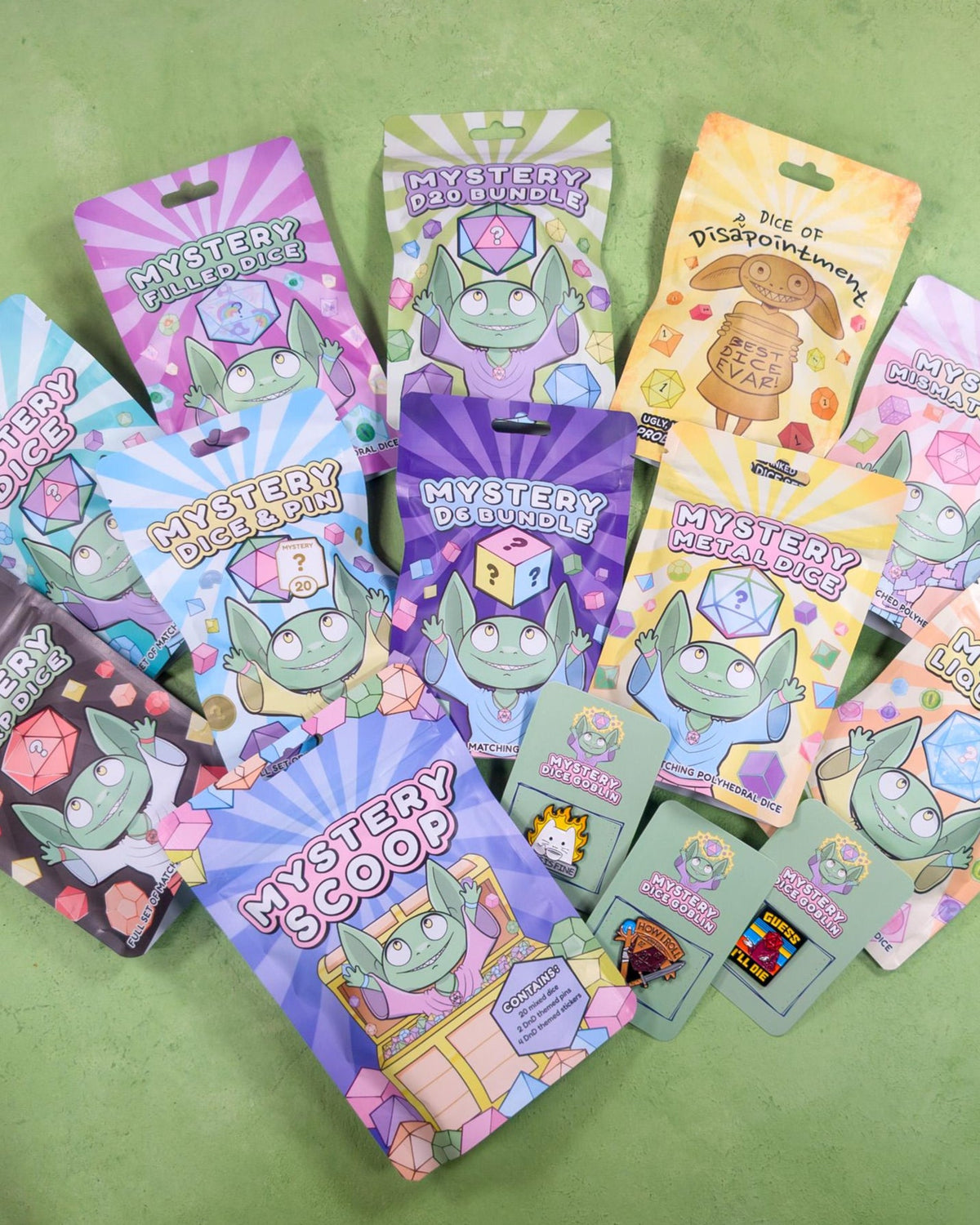 Mystery Dice BIGGER Bundle featuring assorted polyhedral TTRPG dice and goblin-themed pin badges in branded packaging.
