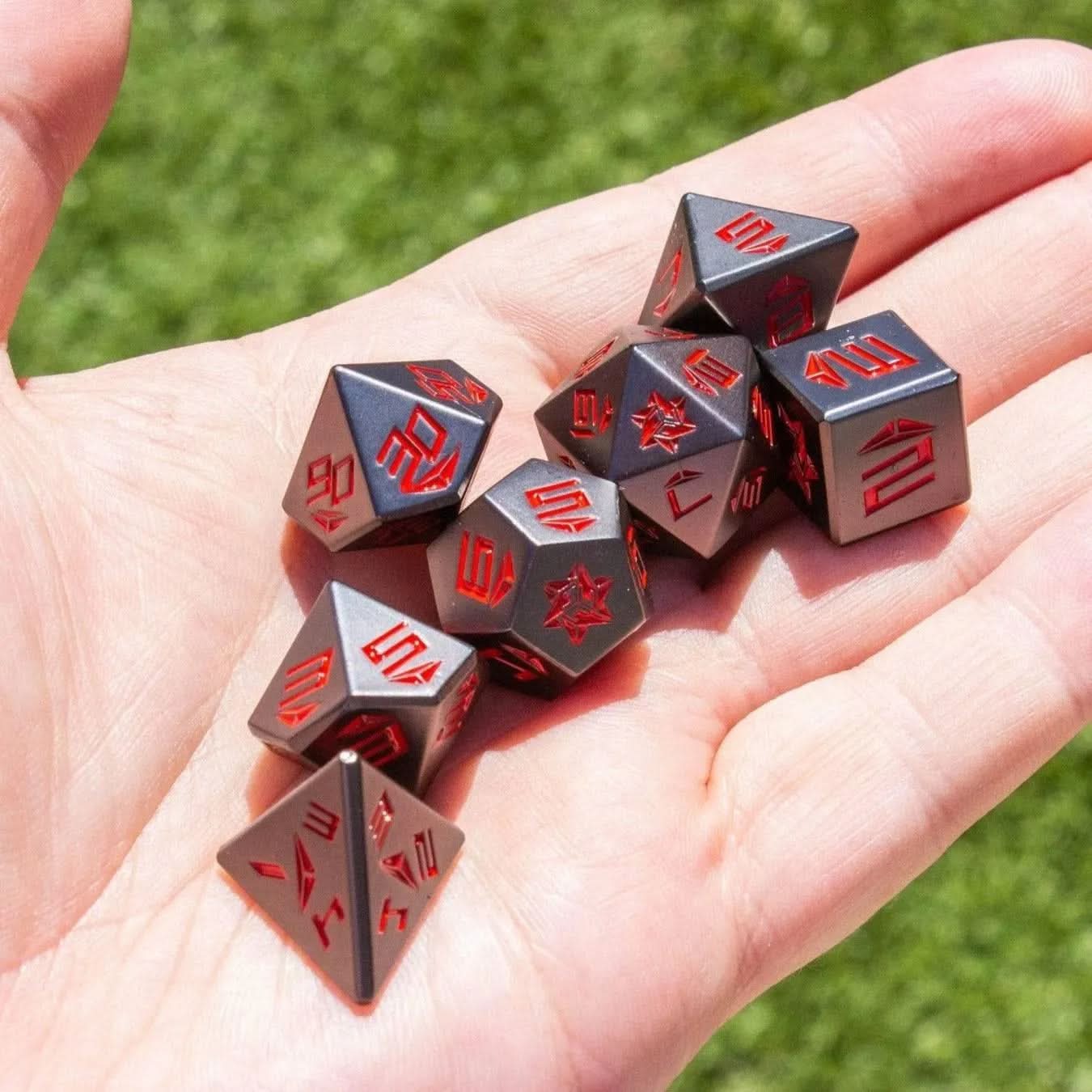 Black and Red Metal Dice Set being held in a hand - Mystery Dice Goblin